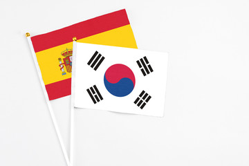 South Korea and Spain stick flags on white background. High quality fabric, miniature national flag. Peaceful global concept.White floor for copy space.