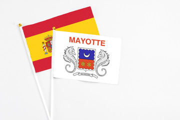 Mayotte and Spain stick flags on white background. High quality fabric, miniature national flag. Peaceful global concept.White floor for copy space.