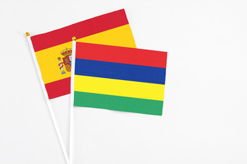Mauritius and Spain stick flags on white background. High quality fabric, miniature national flag. Peaceful global concept.White floor for copy space.
