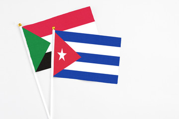 Cuba and Sudan stick flags on white background. High quality fabric, miniature national flag. Peaceful global concept.White floor for copy space.