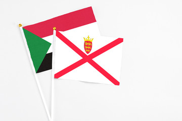 Jersey and Sudan stick flags on white background. High quality fabric, miniature national flag....