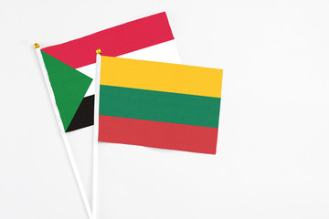 Lithuania and Sudan stick flags on white background. High quality fabric, miniature national flag. Peaceful global concept.White floor for copy space.