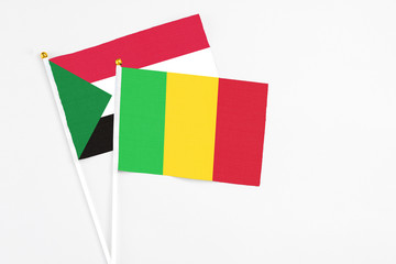 Mali and Sudan stick flags on white background. High quality fabric, miniature national flag. Peaceful global concept.White floor for copy space.