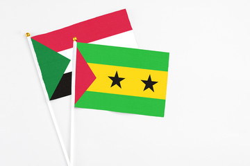 Sao Tome And Principe and Sudan stick flags on white background. High quality fabric, miniature national flag. Peaceful global concept.White floor for copy space.
