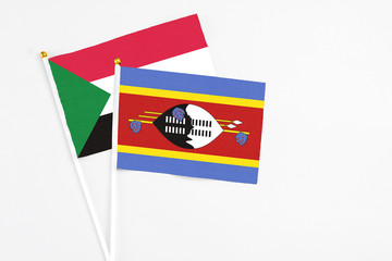 Swaziland and Sudan stick flags on white background. High quality fabric, miniature national flag. Peaceful global concept.White floor for copy space.