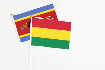Bolivia and Swaziland stick flags on white background. High quality fabric, miniature national flag. Peaceful global concept.White floor for copy space.