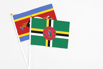Dominica and Swaziland stick flags on white background. High quality fabric, miniature national...