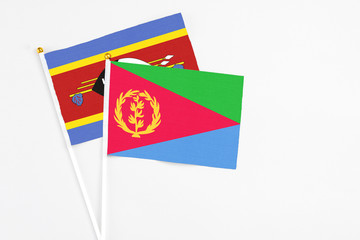 Eritrea and Swaziland stick flags on white background. High quality fabric, miniature national flag. Peaceful global concept.White floor for copy space.