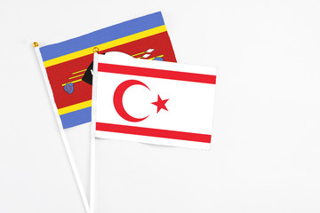 Northern Cyprus and Swaziland stick flags on white background. High quality fabric, miniature national flag. Peaceful global concept.White floor for copy space.