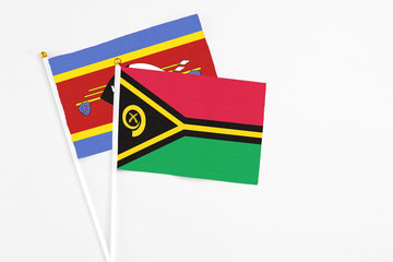 Vanuatu and Swaziland stick flags on white background. High quality fabric, miniature national flag. Peaceful global concept.White floor for copy space.