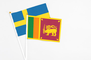 Sri Lanka and Sweden stick flags on white background. High quality fabric, miniature national flag. Peaceful global concept.White floor for copy space.