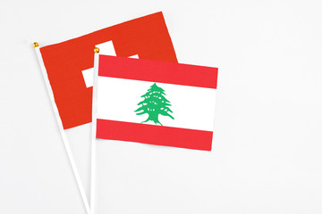 Lebanon and Switzerland stick flags on white background. High quality fabric, miniature national...