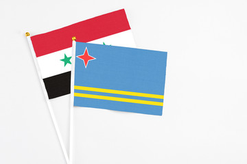 Aruba and Syria stick flags on white background. High quality fabric, miniature national flag....