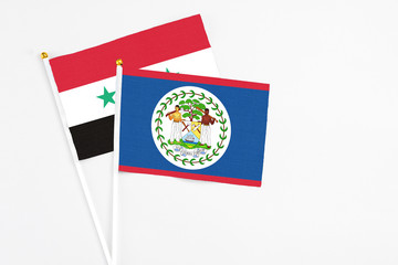 Belize and Syria stick flags on white background. High quality fabric, miniature national flag. Peaceful global concept.White floor for copy space.