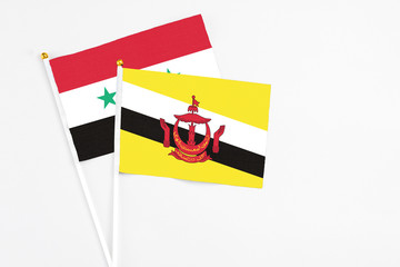 Brunei and Syria stick flags on white background. High quality fabric, miniature national flag....