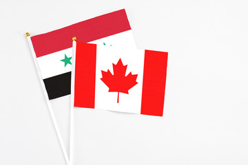 Canada and Syria stick flags on white background. High quality fabric, miniature national flag....
