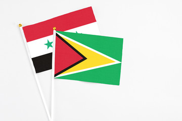 Guyana and Syria stick flags on white background. High quality fabric, miniature national flag....