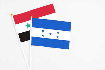 Honduras and Syria stick flags on white background. High quality fabric, miniature national flag....