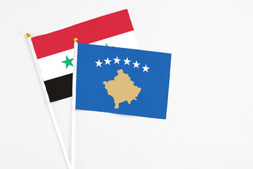Kosovo and Syria stick flags on white background. High quality fabric, miniature national flag....