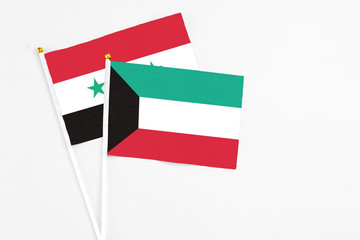 Kuwait and Syria stick flags on white background. High quality fabric, miniature national flag. Peaceful global concept.White floor for copy space.