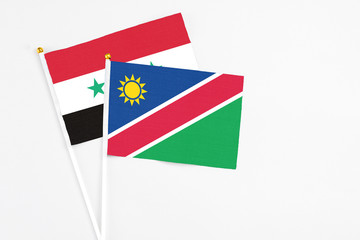 Namibia and Syria stick flags on white background. High quality fabric, miniature national flag....