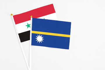 Nauru and Syria stick flags on white background. High quality fabric, miniature national flag....