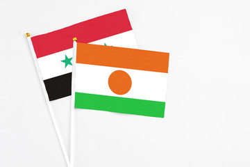 Niger and Syria stick flags on white background. High quality fabric, miniature national flag....