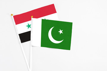 Pakistan and Syria stick flags on white background. High quality fabric, miniature national flag....