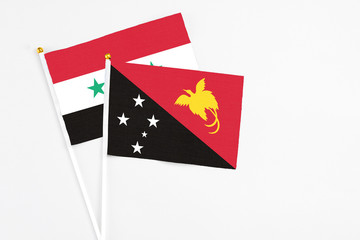 Papua New Guinea and Syria stick flags on white background. High quality fabric, miniature national flag. Peaceful global concept.White floor for copy space.