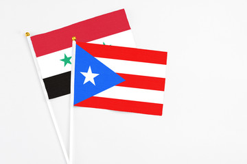 Puerto Rico and Syria stick flags on white background. High quality fabric, miniature national flag. Peaceful global concept.White floor for copy space.