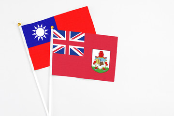 Bermuda and Taiwan stick flags on white background. High quality fabric, miniature national flag. Peaceful global concept.White floor for copy space.