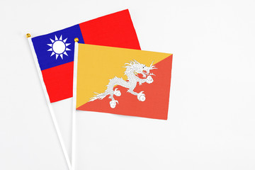 Bhutan and Taiwan stick flags on white background. High quality fabric, miniature national flag. Peaceful global concept.White floor for copy space.