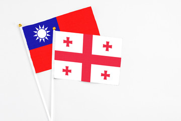 Georgia and Taiwan stick flags on white background. High quality fabric, miniature national flag. Peaceful global concept.White floor for copy space.