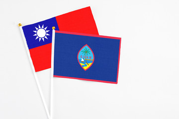 Guam and Taiwan stick flags on white background. High quality fabric, miniature national flag. Peaceful global concept.White floor for copy space.