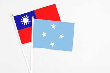 Micronesia and Taiwan stick flags on white background. High quality fabric, miniature national flag. Peaceful global concept.White floor for copy space.