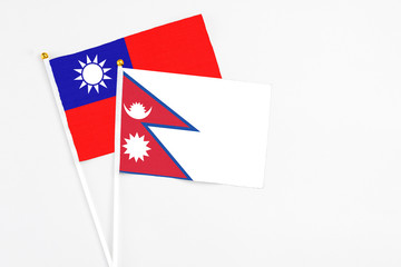 Nepal and Taiwan stick flags on white background. High quality fabric, miniature national flag. Peaceful global concept.White floor for copy space.