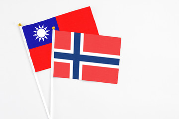 Obraz premium Norway and Taiwan stick flags on white background. High quality fabric, miniature national flag. Peaceful global concept.White floor for copy space.