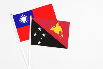 Papua New Guinea and Taiwan stick flags on white background. High quality fabric, miniature national flag. Peaceful global concept.White floor for copy space.