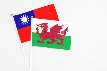 Wales and Taiwan stick flags on white background. High quality fabric, miniature national flag. Peaceful global concept.White floor for copy space.
