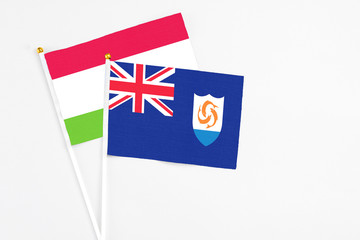 Fototapeta premium Anguilla and Tajikistan stick flags on white background. High quality fabric, miniature national flag. Peaceful global concept.White floor for copy space.