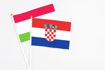 Croatia and Tajikistan stick flags on white background. High quality fabric, miniature national flag. Peaceful global concept.White floor for copy space.