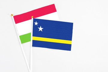 Curacao and Tajikistan stick flags on white background. High quality fabric, miniature national flag. Peaceful global concept.White floor for copy space.