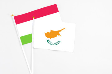 Cyprus and Tajikistan stick flags on white background. High quality fabric, miniature national flag. Peaceful global concept.White floor for copy space.