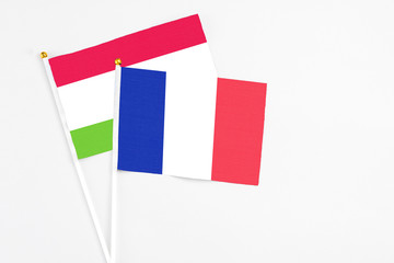 Fototapeta premium France and Tajikistan stick flags on white background. High quality fabric, miniature national flag. Peaceful global concept.White floor for copy space.