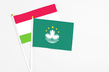 Macao and Tajikistan stick flags on white background. High quality fabric, miniature national flag. Peaceful global concept.White floor for copy space.