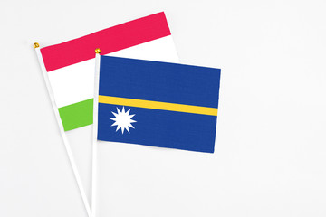 Nauru and Tajikistan stick flags on white background. High quality fabric, miniature national flag. Peaceful global concept.White floor for copy space.