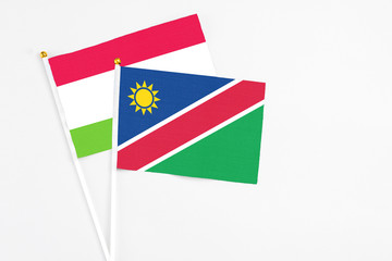 Namibia and Tajikistan stick flags on white background. High quality fabric, miniature national flag. Peaceful global concept.White floor for copy space.
