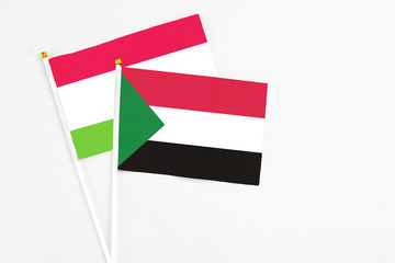 Sudan and Tajikistan stick flags on white background. High quality fabric, miniature national flag. Peaceful global concept.White floor for copy space.