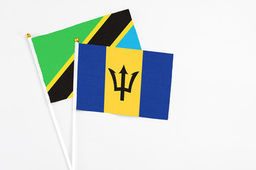 Barbados and Tanzania stick flags on white background. High quality fabric, miniature national flag. Peaceful global concept.White floor for copy space.