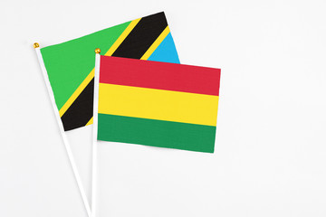 Bolivia and Tanzania stick flags on white background. High quality fabric, miniature national flag. Peaceful global concept.White floor for copy space.